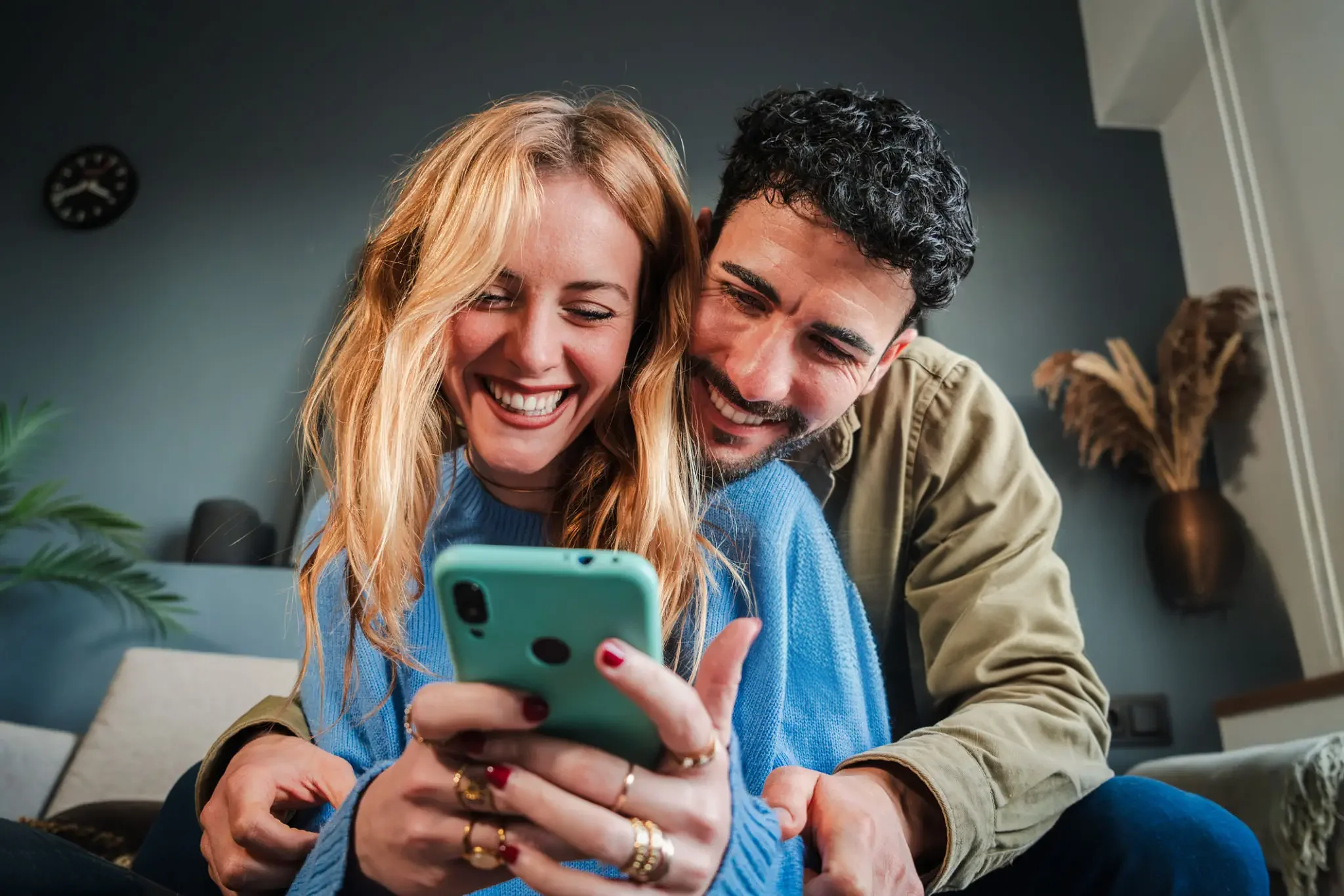 Person smiling while using their smartphone